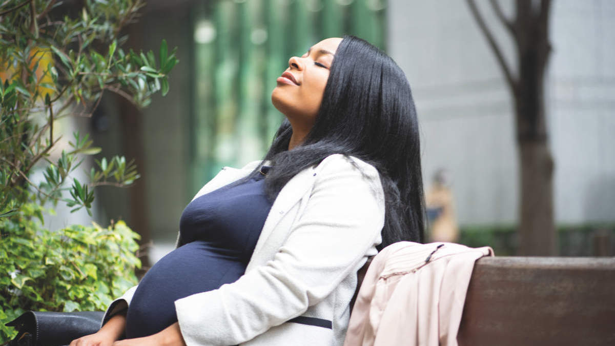 A pregnant woman taking a break from work by sitting outside on a sunny day. AmniSure, Woman Health